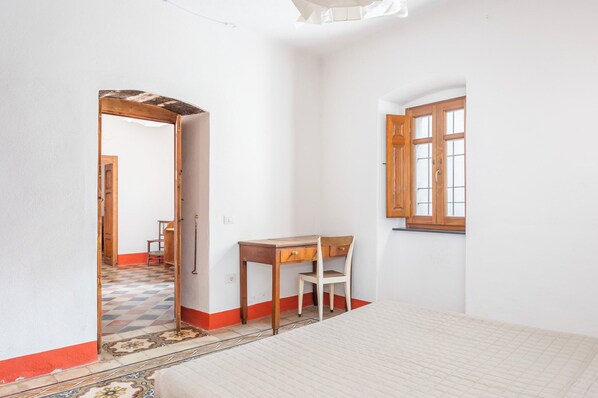 A room with a wooden desk, chair, and a window with wooden shutters. - Casa con terrazza panoramica e servizio e-bike (Seneghe)