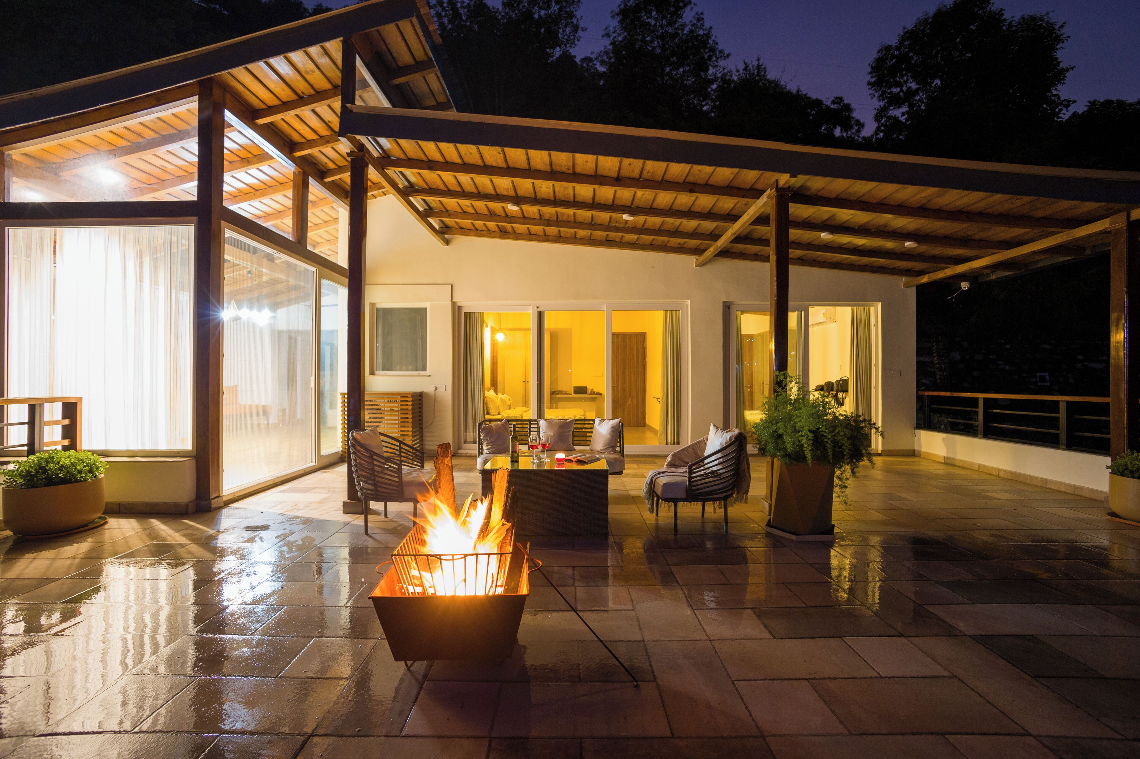 An outdoor patio with a fire feature, seating, and a covered area.