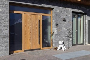 A modern building with large wooden doors and stone walls. - AU - KitzSki Apartment ski-in ski-out accommodation (Mittersill)