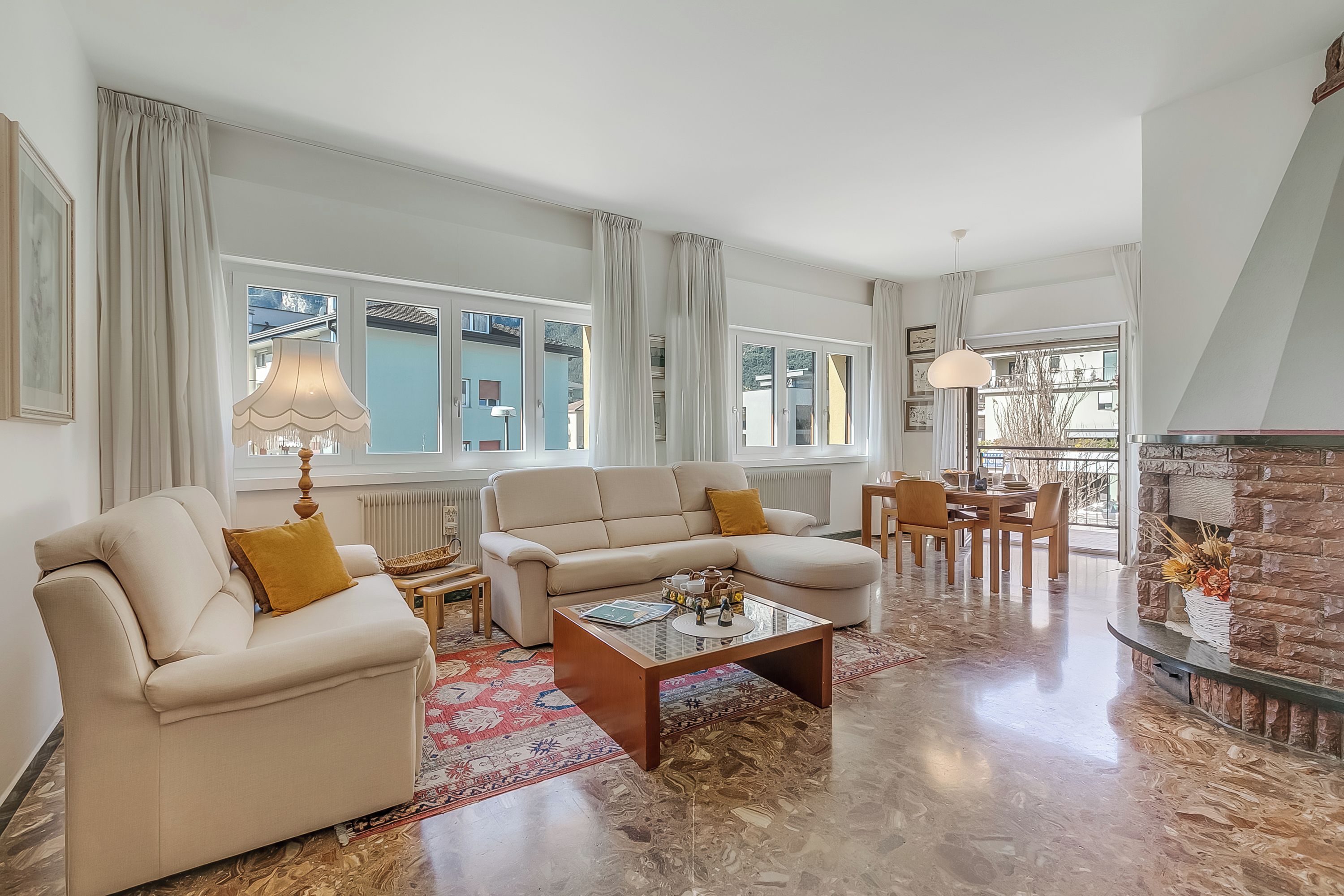A living room with a sofa, coffee table, and dining area.