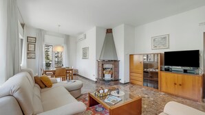 Un salon comprenant un canapé, une table basse, une cheminée, un téléviseur et un meuble en bois.