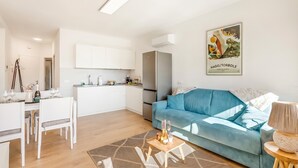 A modern apartment with a dining area, kitchenette, and a blue sofa. - Bella Vista Apartment (Riva del Garda)