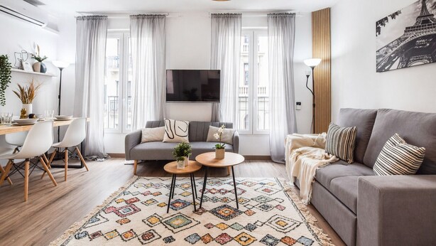 Uma sala de estar moderna com sofá, mesa de centro e área de jantar.