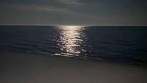 A beach at night with a visible moon reflection on the water. - Waterfront Beach House - Deck, BBQ & Private Beach (Selkirk)