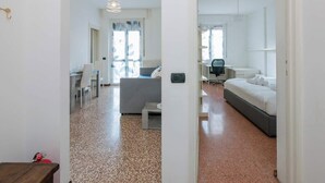 Ein modernes Hotelzimmer mit Bett, Schreibtisch, Stuhl und Blick auf die Straße.