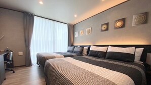 Une chambre d’hôtel avec deux lits, un bureau et une grande fenêtre avec des rideaux.