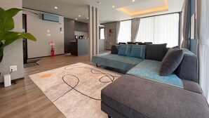 Un salon moderne avec un canapé, un pouf et un tapis.