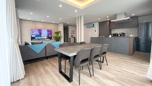 Un salon moderne avec un canapé, une table à manger et un téléviseur.