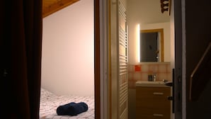 Ein Schlafzimmer mit einem Bett, einem Nachttisch, einem Spiegel und einem Heizkörper.