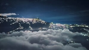 A nighttime view of a city with lights reflecting on clouds. - LuxeHaven Homestay-a Peaceful Escape (Darjeeling)