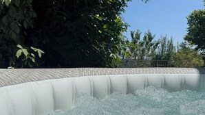 A hot tub with water bubbling, surrounded by greenery and trees. - Belle Vue Bed and Breakfast: Recharge Your Batteries in the Countryside. (Fraisses)