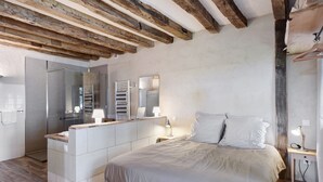 Un dormitorio con cama, mesita de noche y un banco empotrado con espacio de almacenamiento.