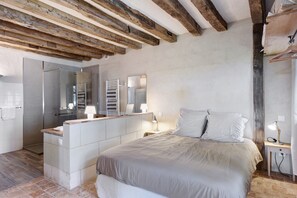 Ein Schlafzimmer mit einem Bett, einem Nachttisch und einer eingebauten Sitzbank mit Stauraum.