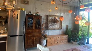 Una cucina con frigorifero, mobili in legno e lampade a sospensione.