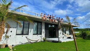 Un edificio moderno con un balcone, un'amaca e un prato curato.