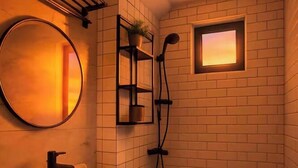 A bathroom with a white vanity, a round mirror, a shower, and a small window. - 康宿·夕观居｜日落海景双卧套房
KanStay Sunset View | 2BR Sunset Ocean View Suite (Manila)