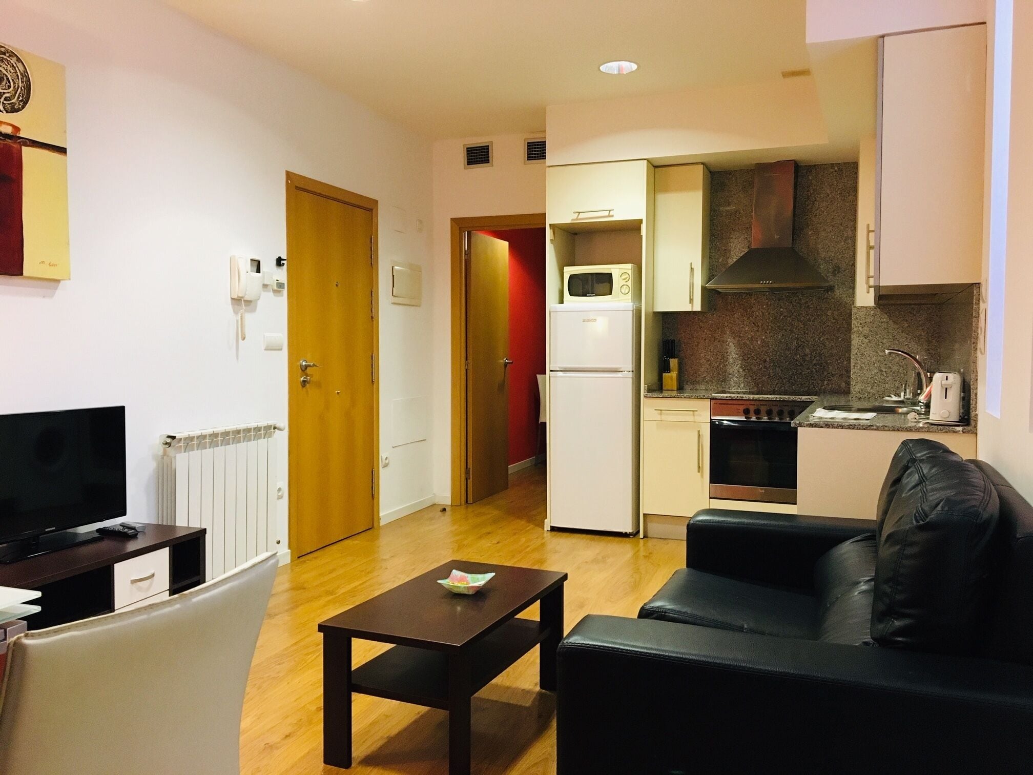 A compact living space with a kitchenette, a dining area, and a seating area.