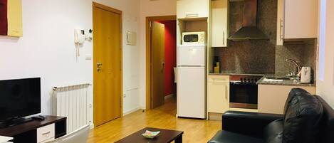 A compact living space with a kitchenette, a dining area, and a seating area.