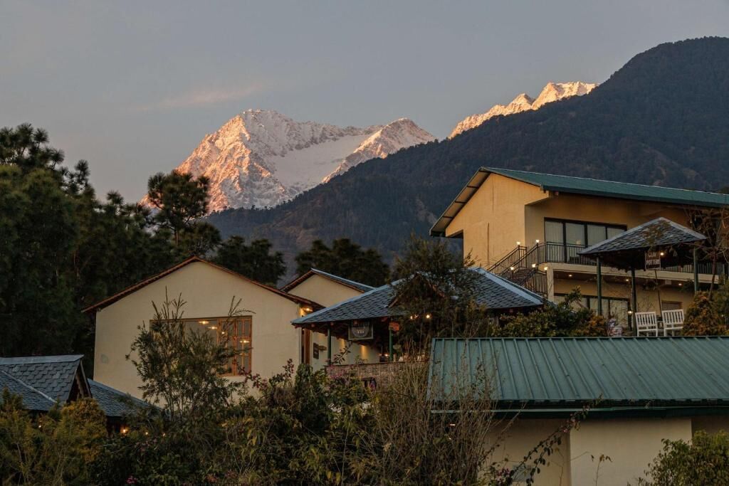 Un hotel con vista a la montaña, un balcón y techo verde.