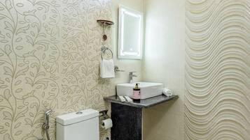 A bathroom with a toilet, sink, and shower.