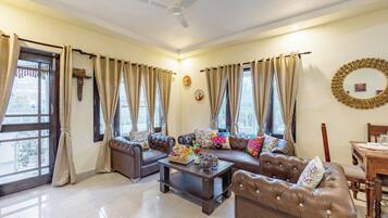 A living room with a sofa set, a coffee table, and a dining table.