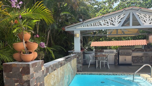 A swimming pool with a stone wall, an outdoor kitchen, and a covered seating area. - 5 minutes from National Forest and 8 of the best beaches / Natural Essence (Luquillo)