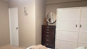 A bedroom with a bed, a dresser, a wardrobe, and a door. - 5 minutes from National Forest and 8 of the best beaches / Natural Essence (Luquillo)