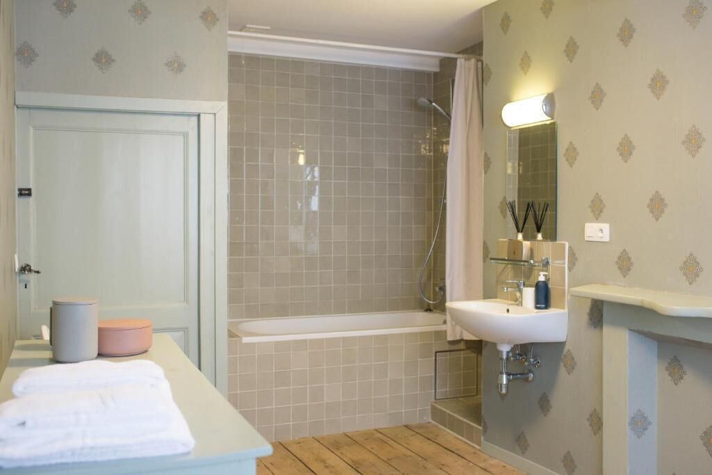 A bathroom with a bathtub, a sink, and a mirror.