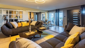 A modern living room with a sofa, coffee table, and dining area. - Luxury vacation apartment with whirlpool for 4-6 people in Crikvenica (Crikvenica)