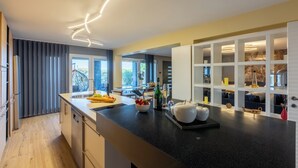 A modern kitchen with a black countertop, built-in shelves, and a view of the outdoors. - Luxury vacation apartment with whirlpool for 4-6 people in Crikvenica (Crikvenica)