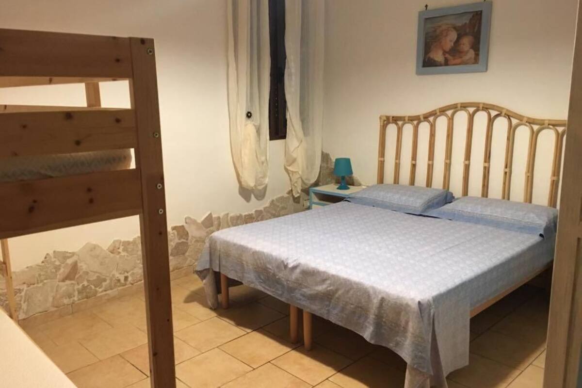 Une chambre à coucher avec un lit, une table de chevet, une lampe et un tableau au mur.
