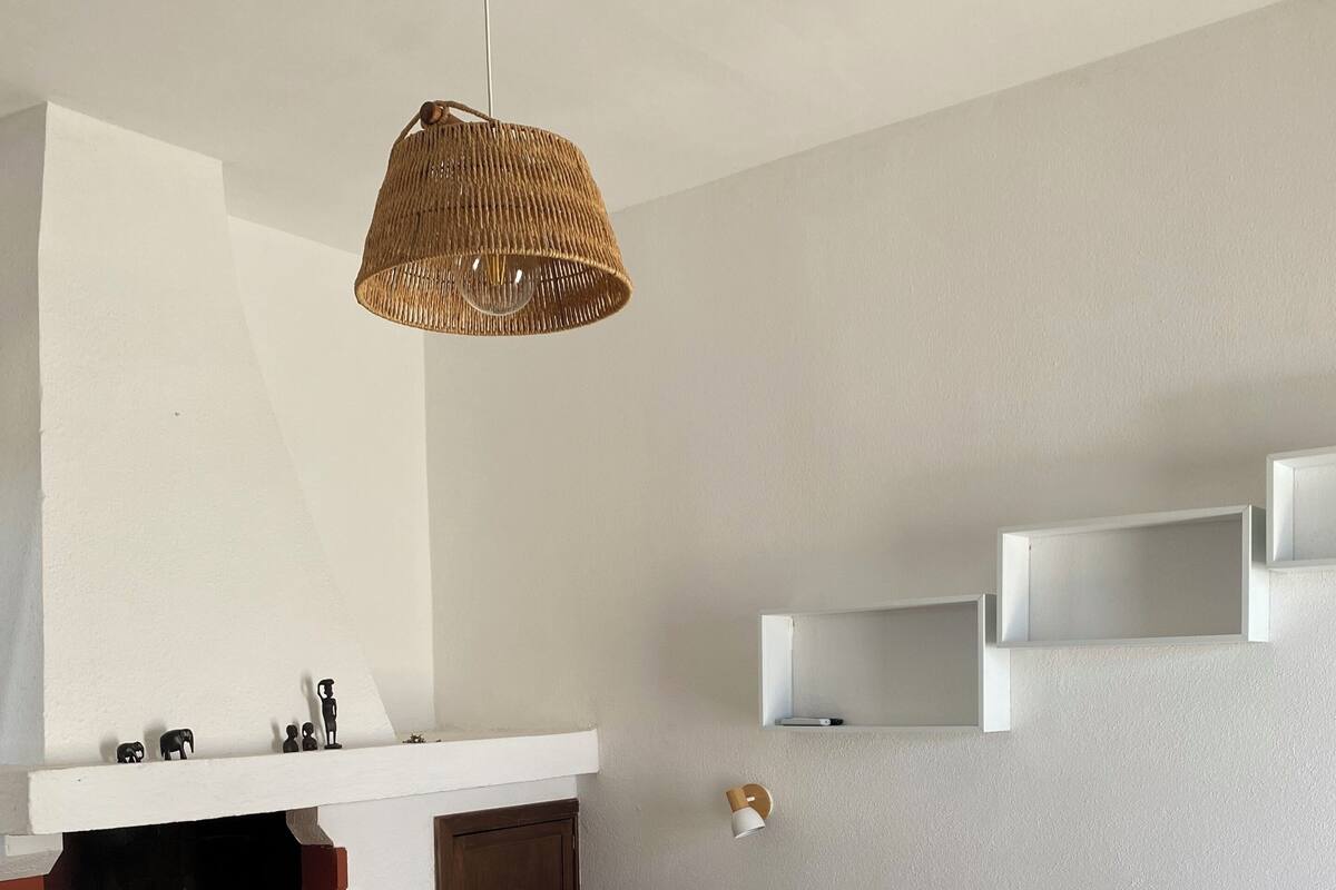 Une chambre dotée d’un grand lit, d’une cheminée, d’un luminaire suspendu et d’étagères intégrées.