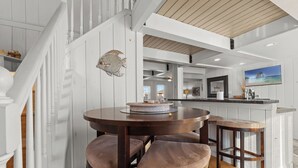 A kitchen with a wooden island, white cabinetry, and a round dining table with four stools. - Family Friendly Waterfront Retreat - Dogs Allowed & Off-Season Discounts (Selbyville)