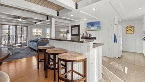 A modern kitchen with a bar area, wooden stools, and a large island. - Family Friendly Waterfront Retreat - Dogs Allowed & Off-Season Discounts (Selbyville)