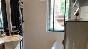 A bathroom with a sink, mirror, and bathtub. - Charming Rooms with free parking (Amsterdam)