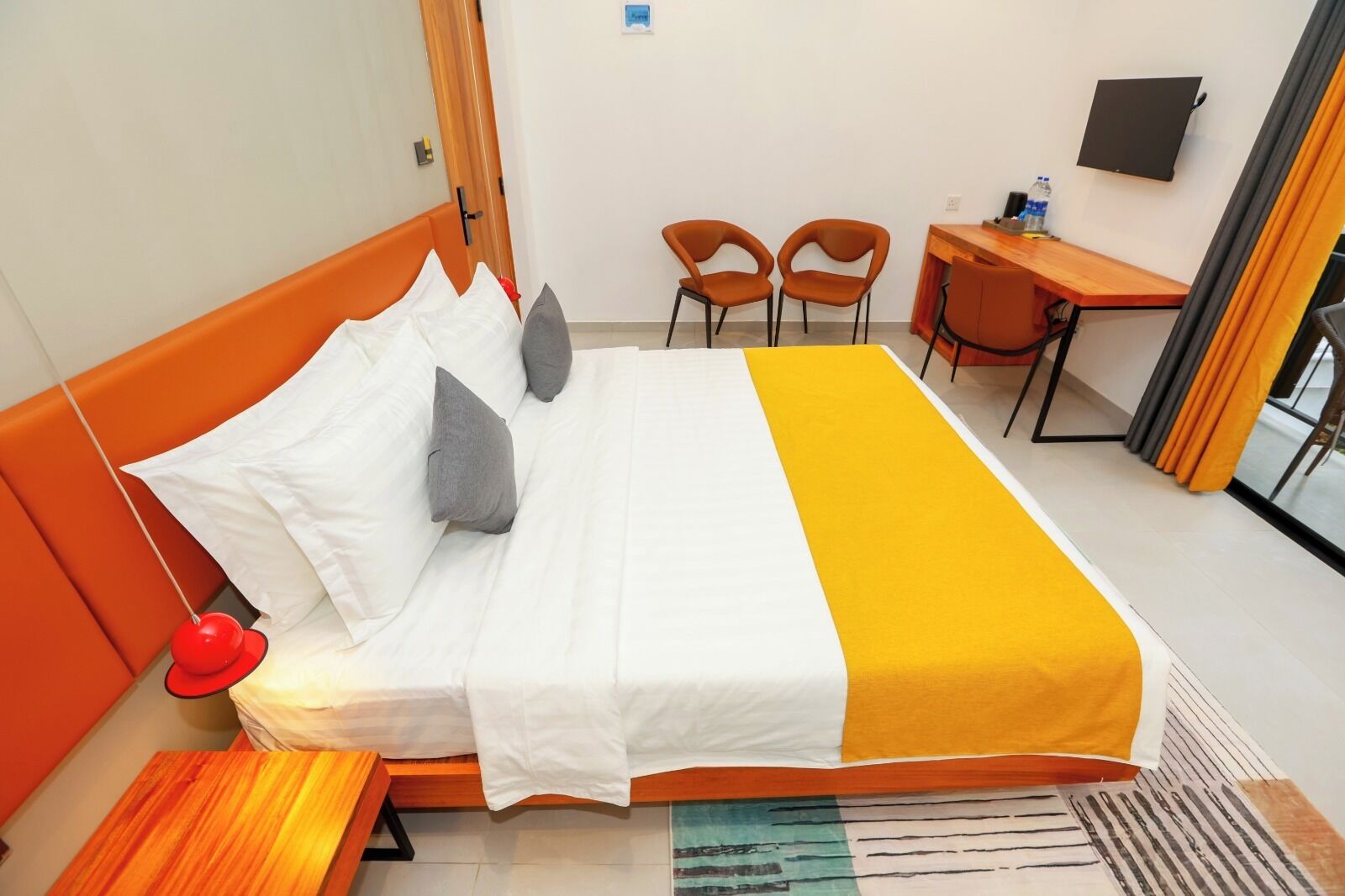 Ein Hotelzimmer mit einem Bett, zwei Stühlen, einem Schreibtisch und einem Fernseher.