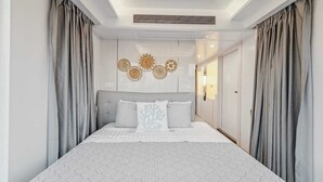 A bedroom with a large bed, grey curtains, a ceiling vent, and wall-mounted decor. - One-of-a-kind tiny home designed for an unforgettable stay by the beautiful San Jacinto River (Highlands)