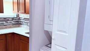 A kitchen with wooden cabinets, a white refrigerator, and a tiled backsplash. - Lovely 4 Bedrooms Family home, 20 minutes from Downtown. (Baltimore)