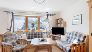 A cozy living room with a sofa set, a television, and a bookshelf. - Apartment 'Haus Grüntensee' with Balcony and Wi-Fi (Wertach)
