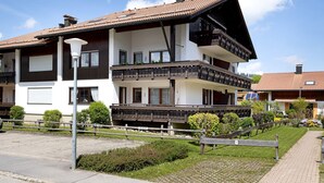 A two-story residential building with a balcony, a paved driveway, and a well-maintained garden. - Apartment 'Haus Grüntensee' with Balcony and Wi-Fi (Wertach)