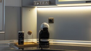 Eine moderne Küche mit Kaffeemaschine, einer Kaffeedose und einem Regal mit schwarzen Kaffeebehältern.