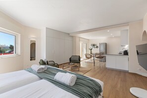 Une chambre d’hôtel moderne équipée d’un lit, d’un petit coin repas et d’une kitchenette.