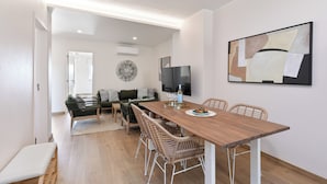 A modern living space with a dining area, a sofa, and a television. - Atlântico Azul - Apartment E (Lagos)