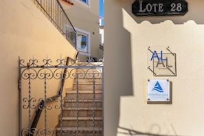 Ein Metallgitter mit einer Treppe, die zu einem Gebäude führt, einem Schild mit der Aufschrift 'LOTE 28' und dem Logo von 'atlántico azul' an der Wand.