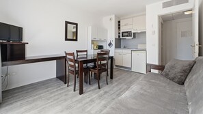 A compact living space with a dining area, kitchenette, and a sofa. - Charming apartment for 4 people near shops (Grasse)