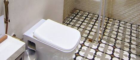 Une salle de bain avec une baignoire, des toilettes et une douche.