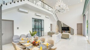 Un intérieur moderne comprenant un coin repas, un escalier et un espace de vie.