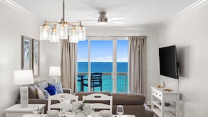 Un soggiorno moderno con angolo ristoro, televisione e balcone vista oceano.