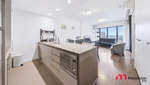 Una cucina moderna con isola centrale, forno integrato e zona pranzo con divano e sedie.