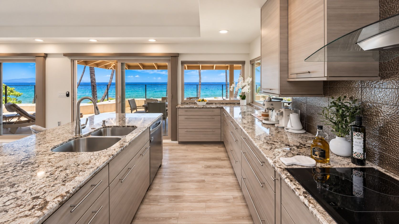 A modern kitchen with a large island, granite countertops, and a view of the ocean.